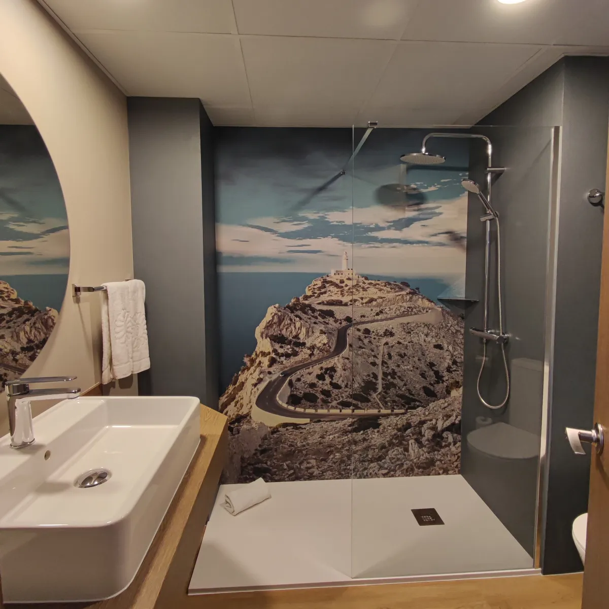 Habitación piloto del Bahía Príncipe Coral Beach: lavabo sobre encimera de madera y ducha con fotomural
