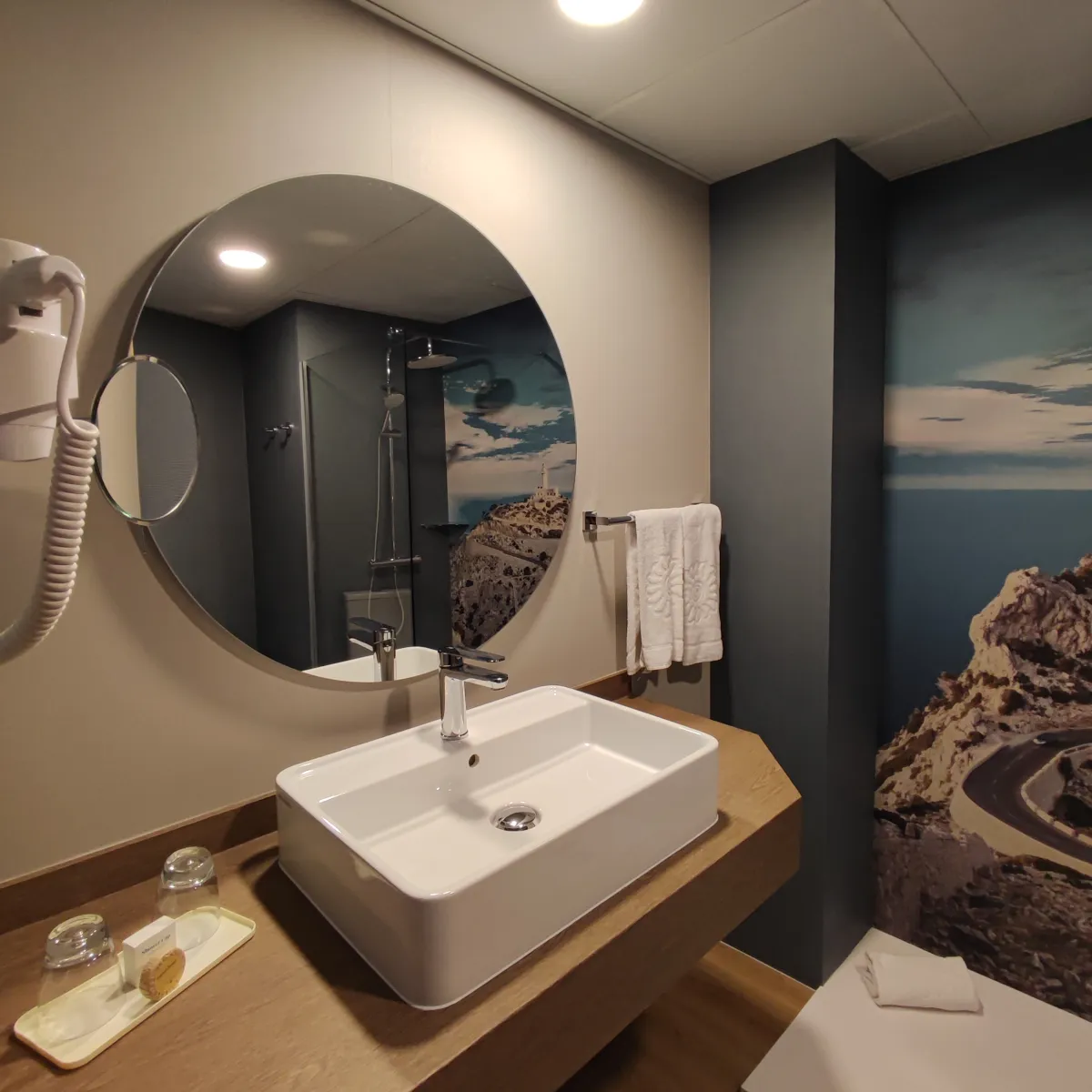 Habitación piloto del Bahía Príncipe Coral Beach: lavabo y espejo redondo de un baño reformado