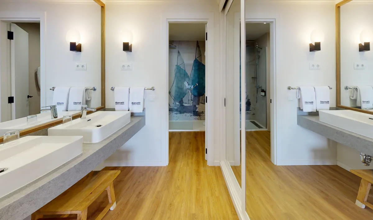 Baño de la habitación Royal 1723 del Barceló Lanzarote con doble lavabo y mural de veleros en la ducha