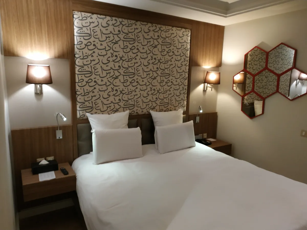 Zona de estar de una habitación del Barceló Marrakech con sofá, mesa redonda y butacas