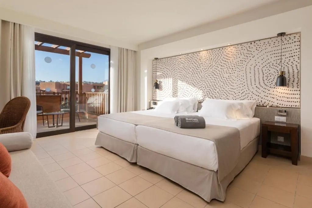 Habitación del Barceló Tenerife con pared de cabecero estampada y terraza