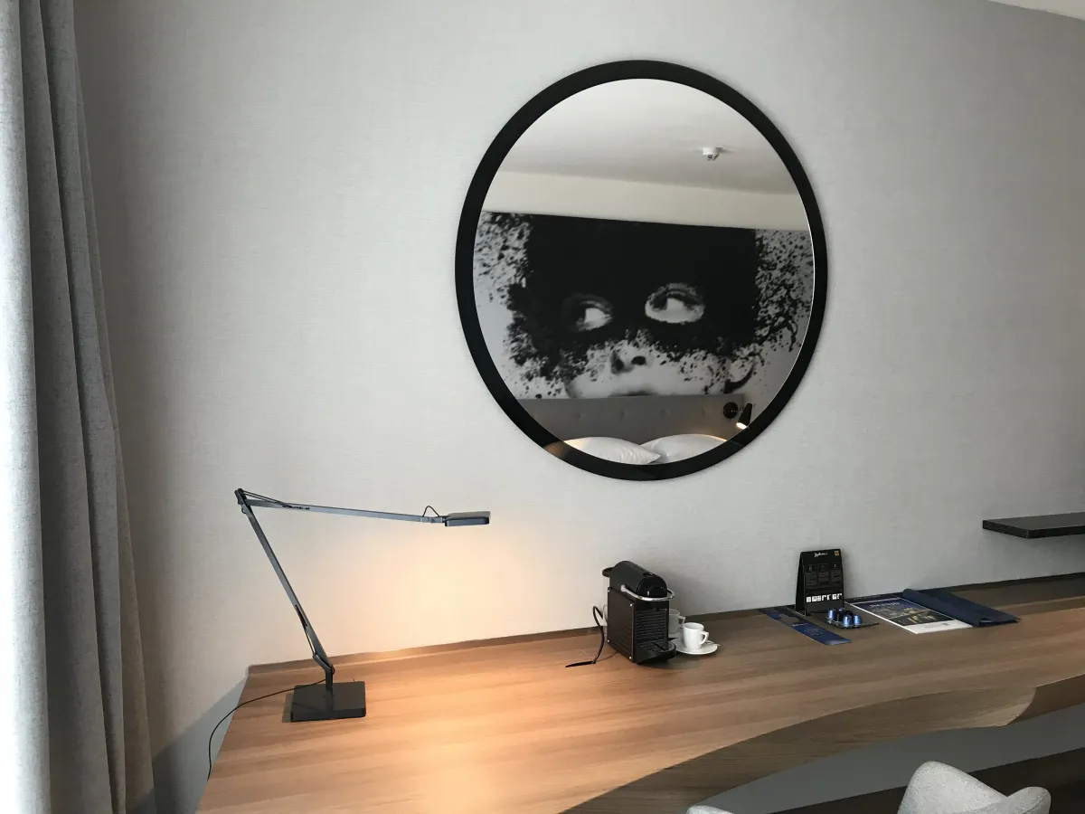 Escritorio del Radisson Blu Colonia con el mural del rostro reflejado en el espejo