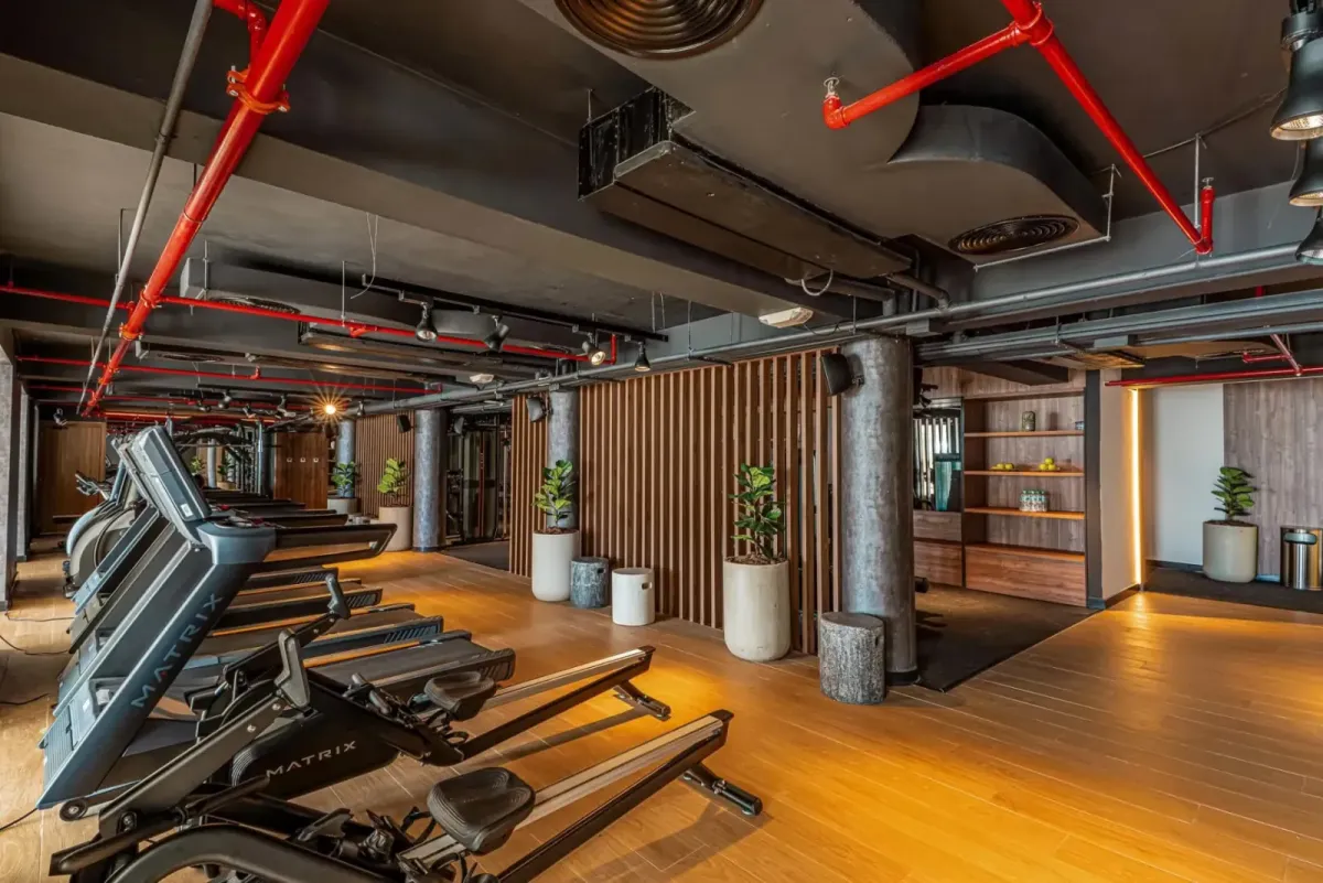 Gimnasio nuevo del Santo Domingo Bay, con techo negro y tuberías rojas vistas